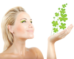 beautiful blonde woman holding four leaf clovers